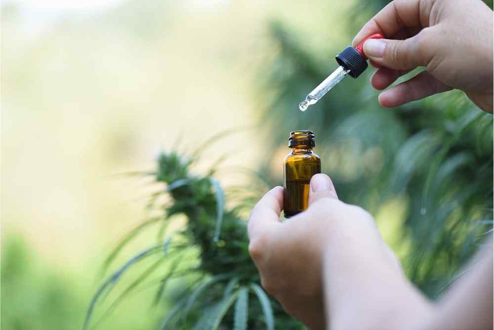 woman using cbd tincture dropper