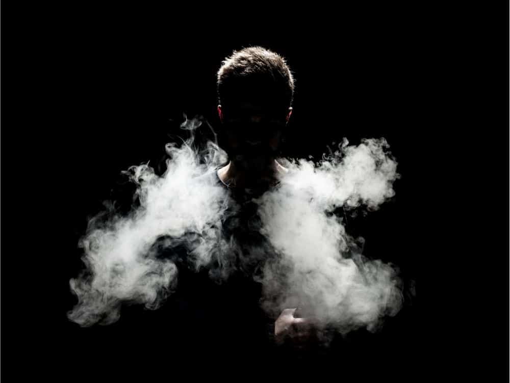 man-inhaling-HHC-in-dark