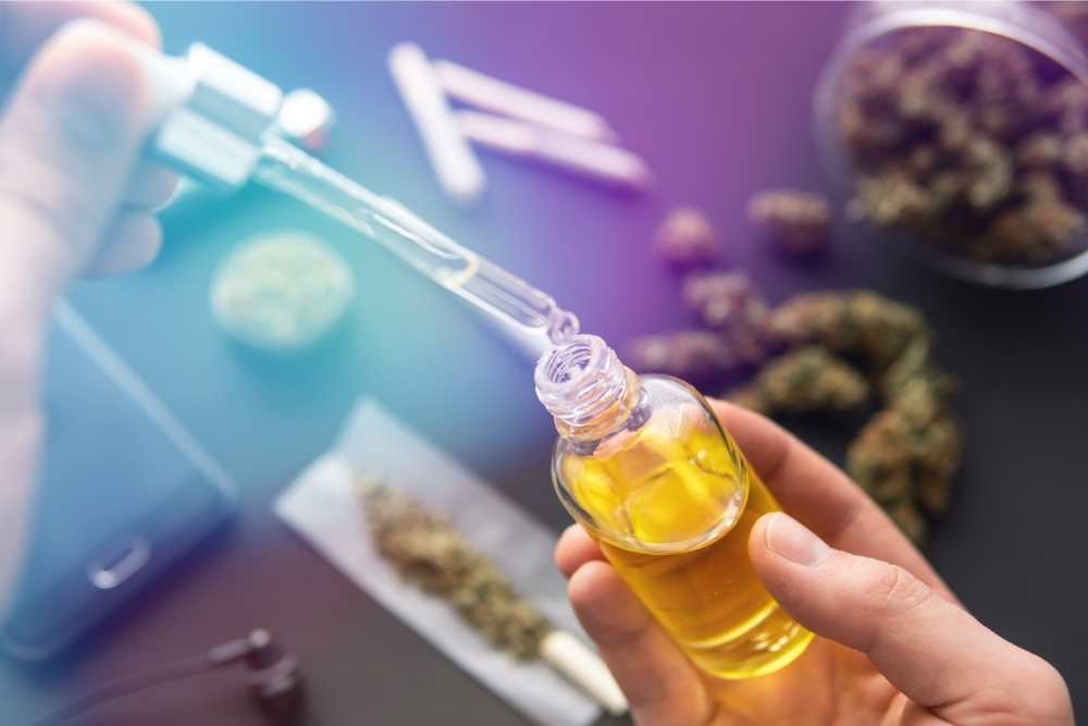 oil bottle with cannabis in the background