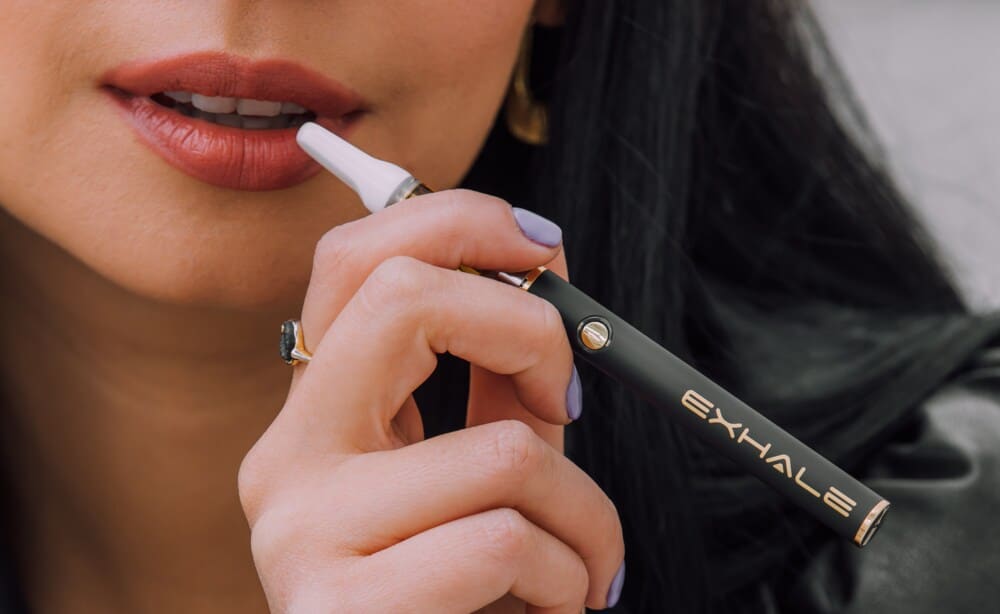 woman holding exhale delta 8 thc vape pen