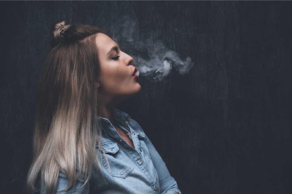 woman exhaling hhc vape smoke from mouth