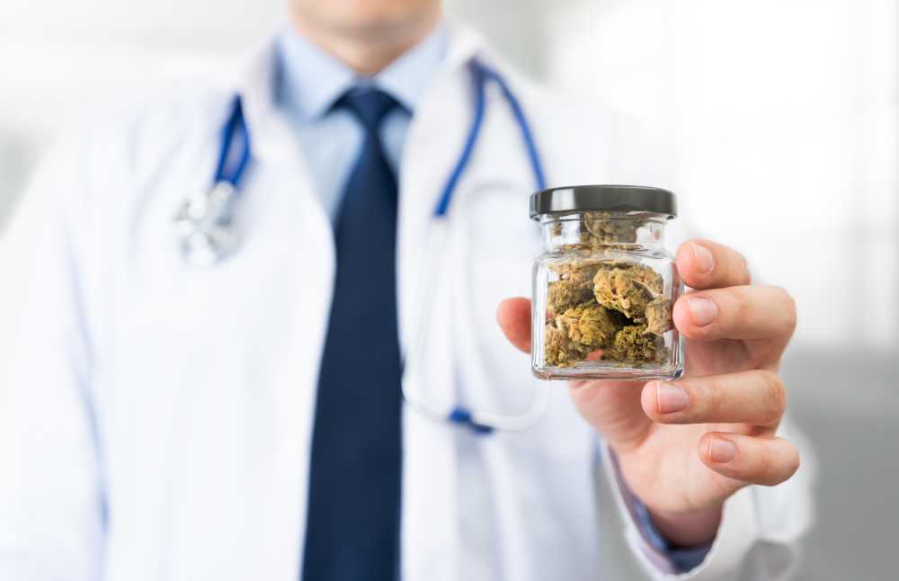 doctor holding jar of cannabis