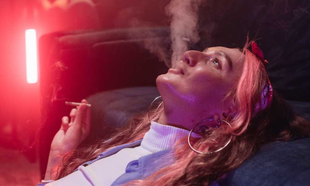 woman looking at ceiling smoking joint