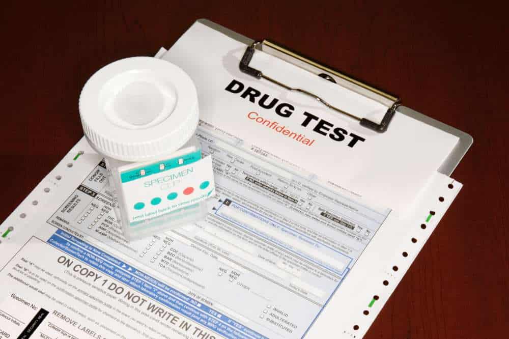 specimen cup on drug test paper