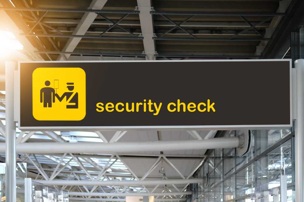 yellow and black security check sign at airport